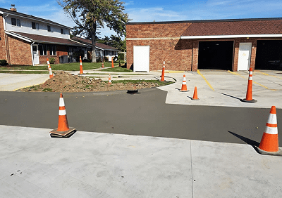 Wet concrete surrounded by traffic cones